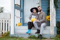 Young woman and man, family, sitting on porch of village house with pumpkins. Royalty Free Stock Photo