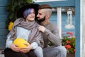 Young woman and man, family, sitting on porch of village house with pumpkins. Royalty Free Stock Photo