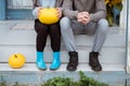 Young woman and man, family, sitting on porch of village house with pumpkins. Royalty Free Stock Photo