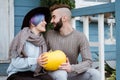 Young woman and man, family, sitting on porch of village house with pumpkins. Royalty Free Stock Photo