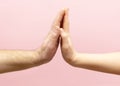 young woman and man holding hands together on pink background. Royalty Free Stock Photo