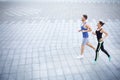 Young woman and man jogging in city copy space Royalty Free Stock Photo