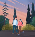 Young woman and man in love, holding each other s hand, walking outdoor along the forest road Royalty Free Stock Photo