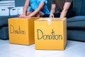 Young woman, man packing stuff clothes, give second hand for donate. reused for donation Royalty Free Stock Photo