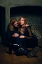 Young woman and man sitting on the floor in wine vault