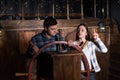 Young woman and man stand at the helm of the ship and trying to