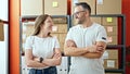 Young woman and man working on ecommerce standing looking at the camera at office Royalty Free Stock Photo