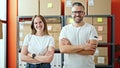 Young woman and man working on ecommerce standing looking at the camera at office Royalty Free Stock Photo