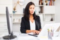 Young woman manager with laptop and documents at office