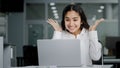 Young woman manager sitting in office looking at laptop screen receiving notification reads good news rejoices in Royalty Free Stock Photo