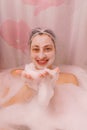 Young woman with a mask on her face is lying in the bathroom