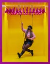 Young woman with mask on swing with yellow background