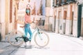 Young woman with mask, walks with her bicycle through the streets of an old town Royalty Free Stock Photo