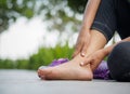 Young woman massaging her painful foot from exercising Royalty Free Stock Photo