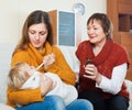 Young woman with mature mother caring for baby