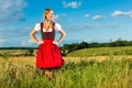 Young woman on meadow wearing dirndl Royalty Free Stock Photo