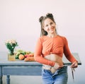 Young woman measures the girth around her waist by the measuring tape on a background of healthy food on a table Royalty Free Stock Photo