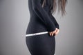 Young woman measures her waist with tape Royalty Free Stock Photo