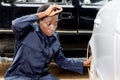 Young woman mechanic changing a tire of a car. Royalty Free Stock Photo