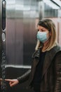 Young woman with medical mask in the elevator