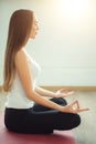 Young woman meditates while practicing yoga