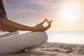 Young woman meditating on beach at sunrise, closeup. Practicing yoga Royalty Free Stock Photo