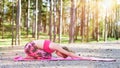 Young woman meditating in Hare position practicing yoga in a forest. Royalty Free Stock Photo