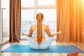 Young woman meditating at home. Girl practicing yoga in class. Relaxation at home, body care, balance, healthy lifestyle Royalty Free Stock Photo