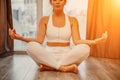 Young woman meditating at home. Girl practicing yoga in class. Relaxation at home, body care, balance, healthy lifestyle Royalty Free Stock Photo