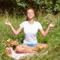 Young woman meditating in lotus position while doing yoga in a wonderful forest. Travel, Healthy Lifestyle concept Royalty Free Stock Photo