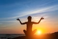 Young woman meditation on the ocean during amazing sunset. Royalty Free Stock Photo