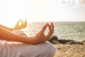 Young woman meditation yoga pose on tropical beach with sunlight