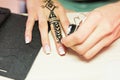 Young woman mehendi artist painting henna on the hand