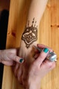 Young woman mehendi artist painting henna on the hand