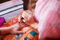 Young woman mehendi artist painting henna on the hand for man Royalty Free Stock Photo