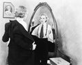 Young woman in men's clothing getting undressed in front of a mirror Royalty Free Stock Photo