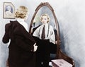 Young woman in men's clothing getting undressed in front of a mirror Royalty Free Stock Photo