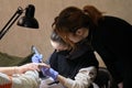 A young woman mentor teacher coach conducts individual training in manicure techniques