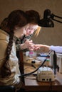 A young woman mentor teacher coach conducts individual training in manicure techniques