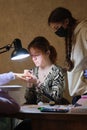 A young woman mentor teacher coach conducts individual training in manicure techniques