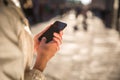 Young woman messaging/using an app on her smart-phone in a city Royalty Free Stock Photo