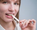 Young woman with metal braces on her teeth is chewing gum. The girl is eating gummy candy Royalty Free Stock Photo