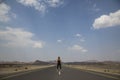 Young woman in the middle of an emty road in rural Oman