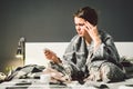 Young woman with a migraine on bed. sick young woman sitting in bed and holding head during headache. COVID-19 or Royalty Free Stock Photo