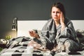 Young woman with a migraine on bed. sick young woman sitting in bed and holding head during headache. COVID-19 or Royalty Free Stock Photo