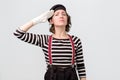 Young woman mime looking at camera and saluting Royalty Free Stock Photo