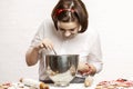 A young woman mixes the ingredients in a large bowl for baking Christmas cookies