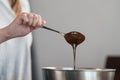 Young woman mixing chocolate in steel bowl to make candys Royalty Free Stock Photo