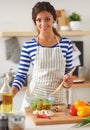 Young woman mixing fresh salad