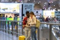 Young woman with mobile phone helping african man traveler in airport, showing direction on map Royalty Free Stock Photo